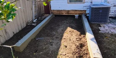 Freshly poured concrete footing and beam forms for a room addition on an RGV home